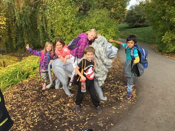 Children standing with statue of lion.